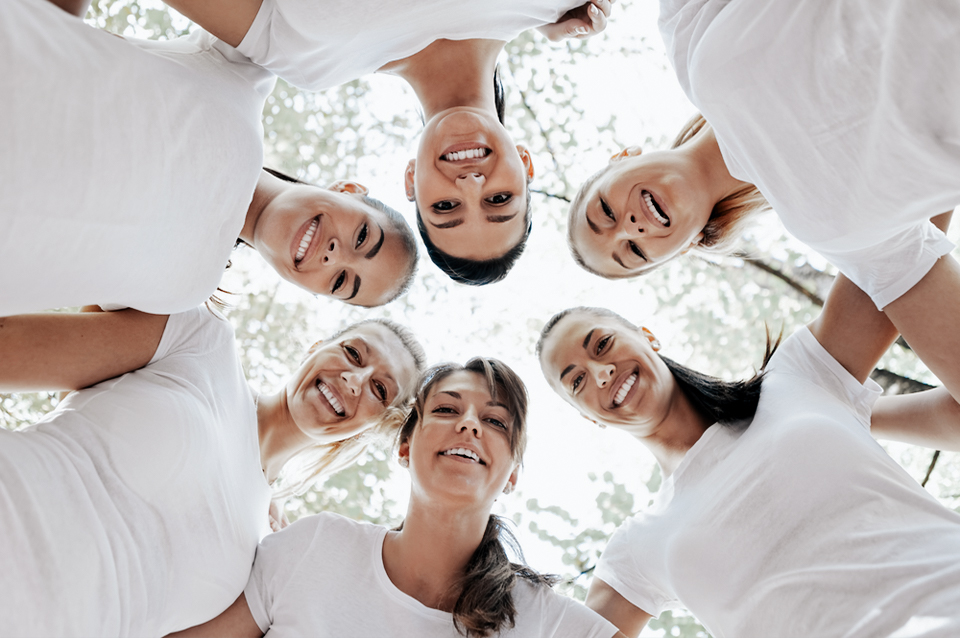 group of friends standing in a circle smiling and discussing egg donor compensation