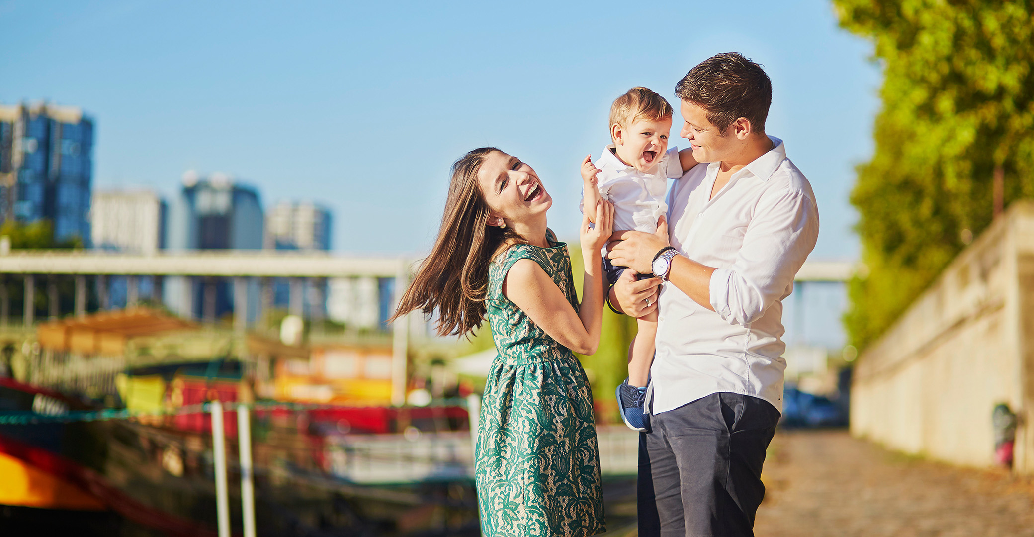 Laughing parents holding a happy little boy