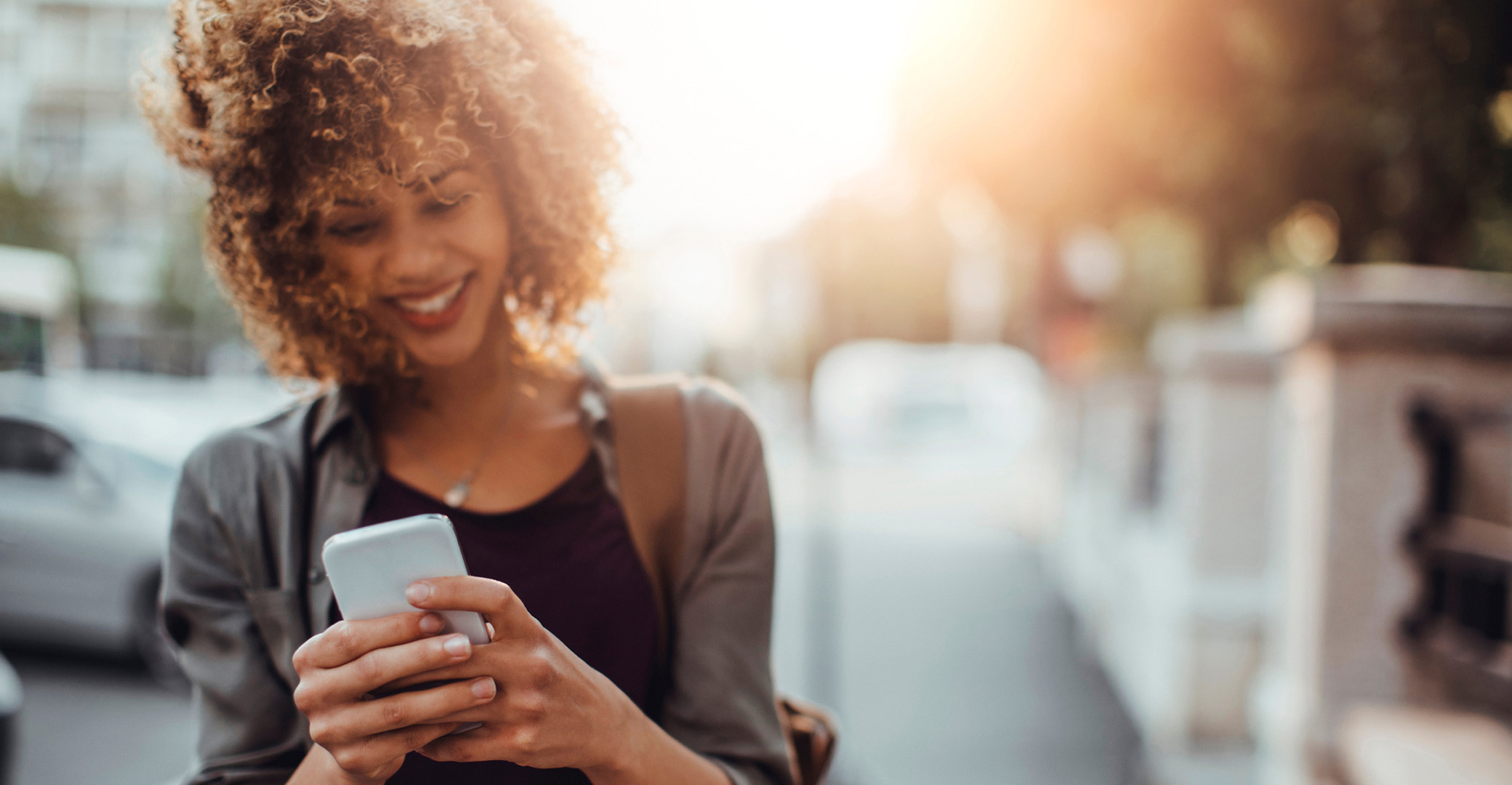 Young woman smiling and looking at her phone