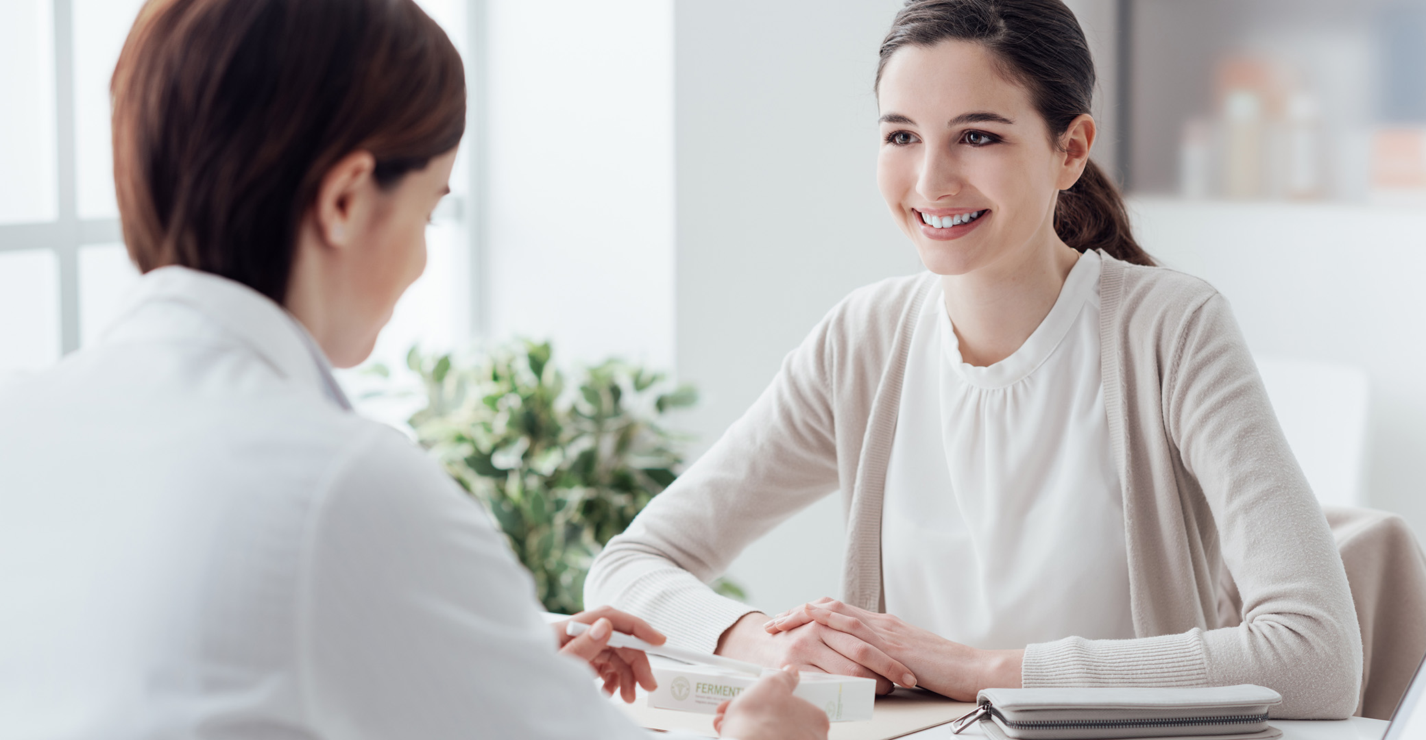 young woman smiling as doctor explains process