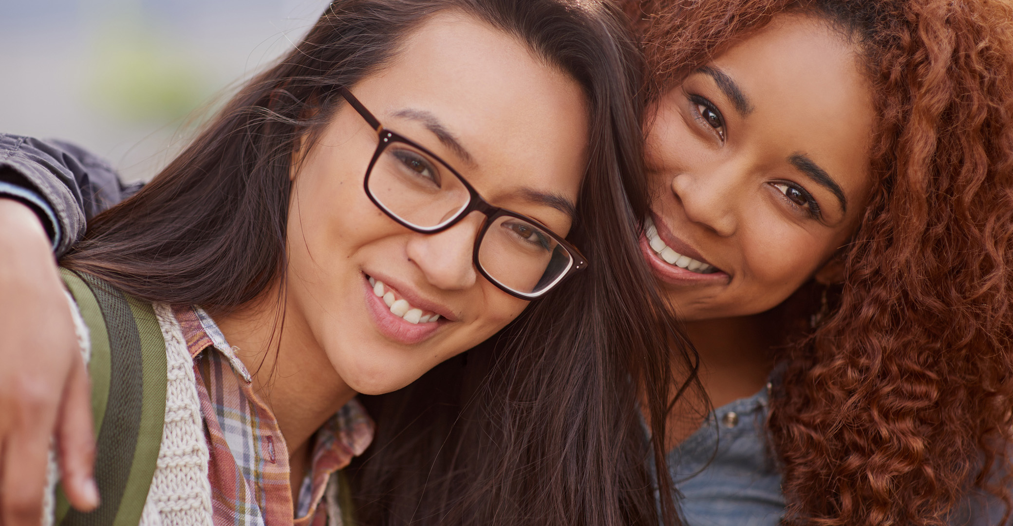 young woman with her arm around another woman in support