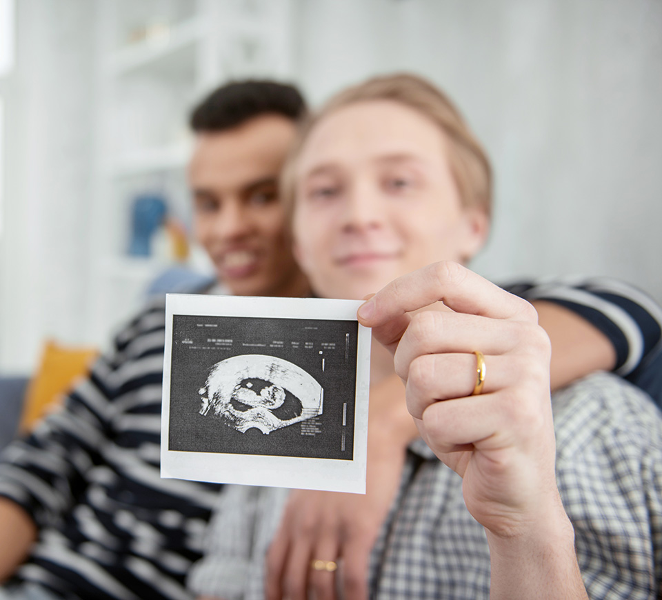 male couple holding ultrasound photo