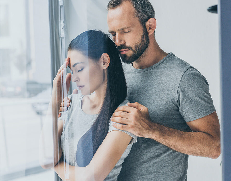 What is a non-viable pregnancy - Husband comforting wife in front of window