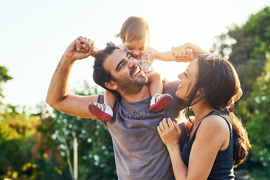 happy family, dad with daughter on shoulders and mother