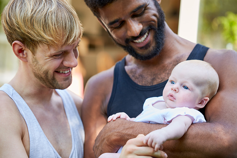 loving male couple cuddling baby daughter