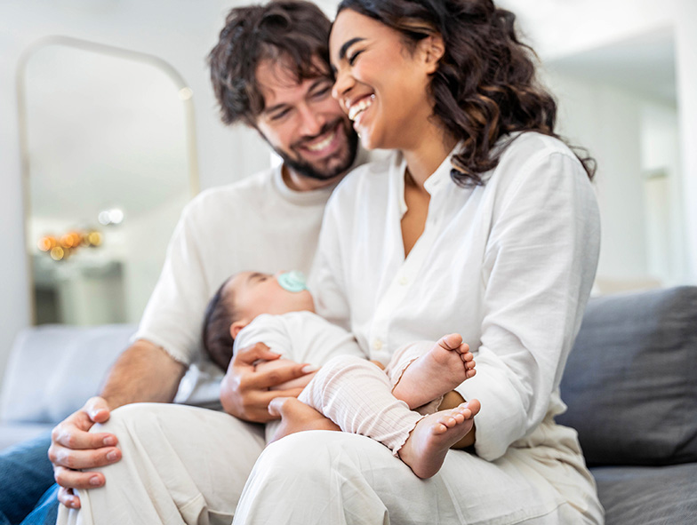 mother and father holding sleeping baby