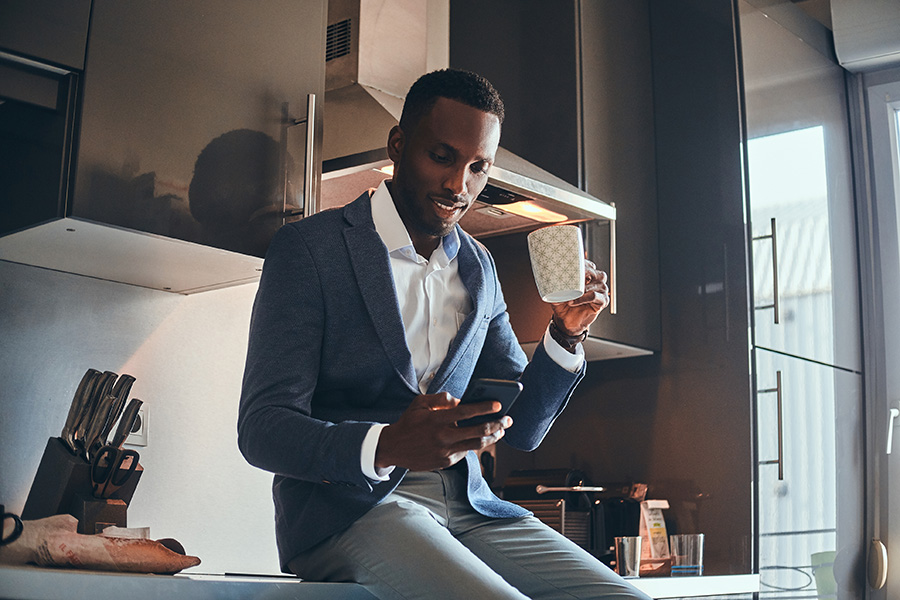 private client services - sophisticated black businessman drinking coffee and looking at phone