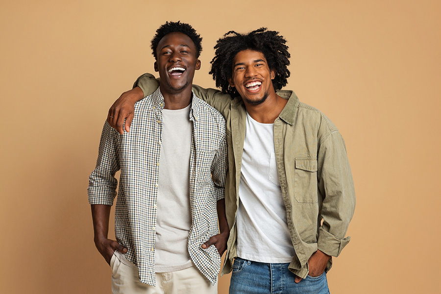 male couple laughing with arm on shoulder